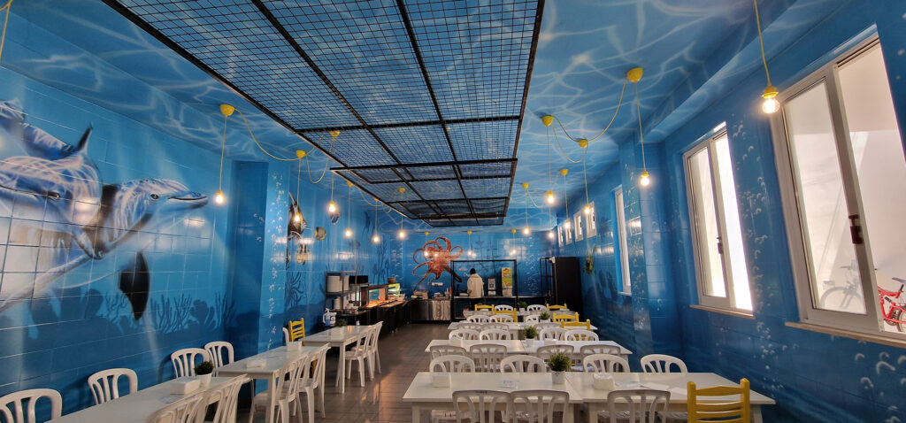 Underwater themed mural with dolphins and ocean life in staff cafeteria at Aliathon Resort Cyprus