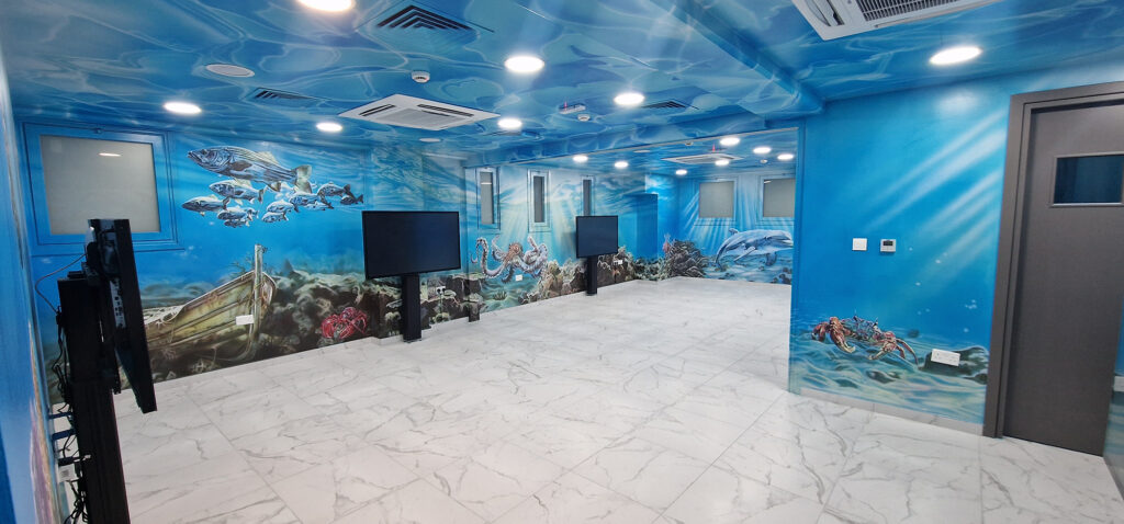 Immersive underwater mural with sea life covering walls and ceiling in interactive ocean room, Limassol, Cyprus.